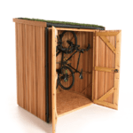 A vertical bike shed crafted from Scottish Larch cladding wood, featuring a green grass roof. Its double doors are open, revealing bicycles stored vertically on a wall mount inside.